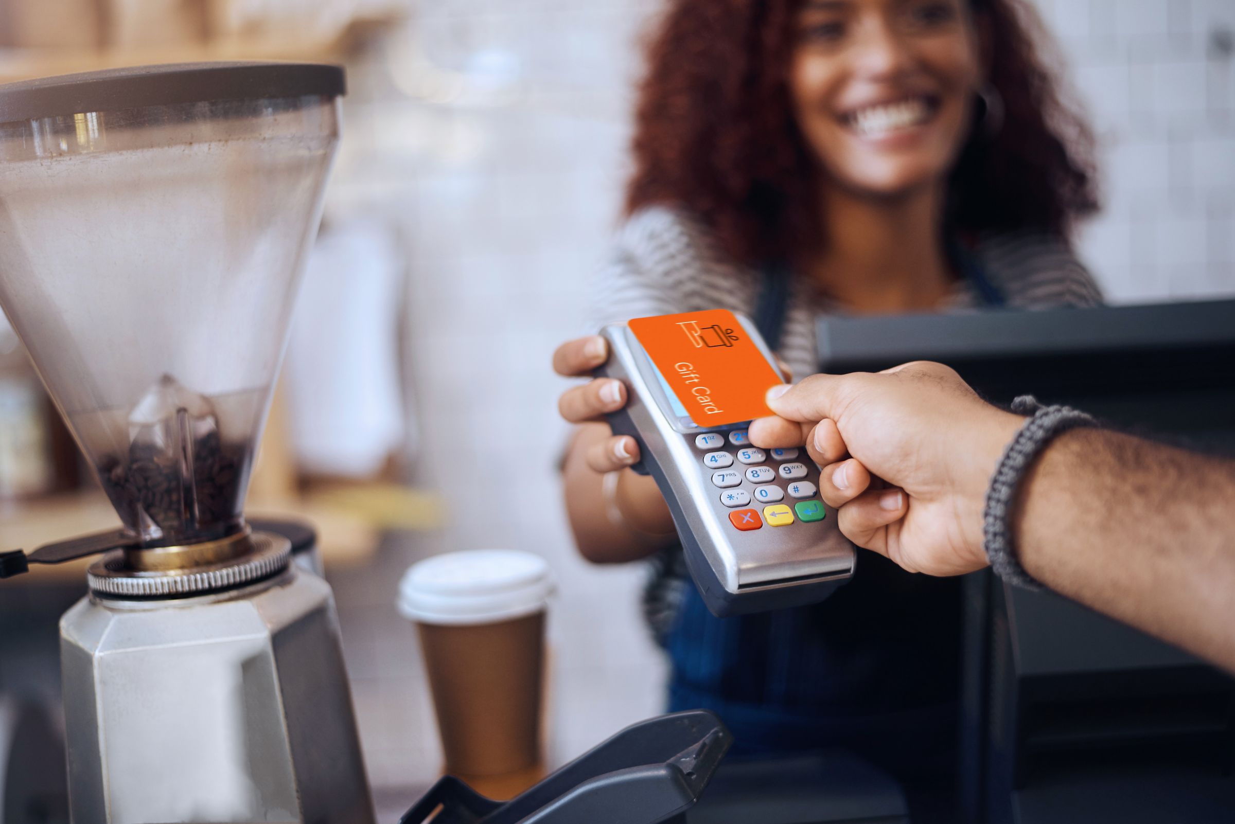 a close-up hand of a person paying with a gift electronic card