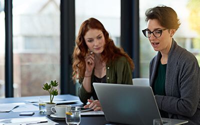 Two people looking at a laptop computer