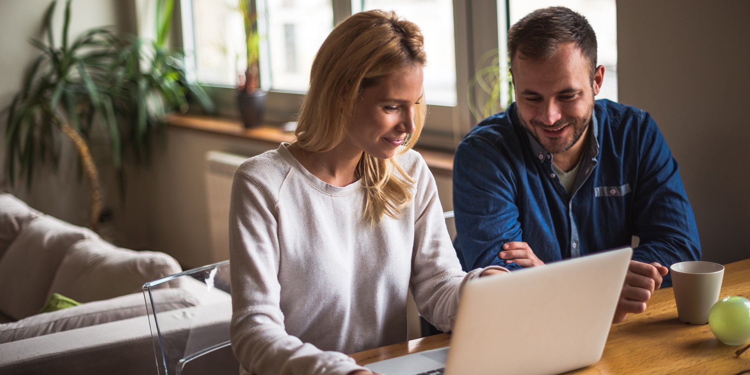 a man and woman looking at a laptop