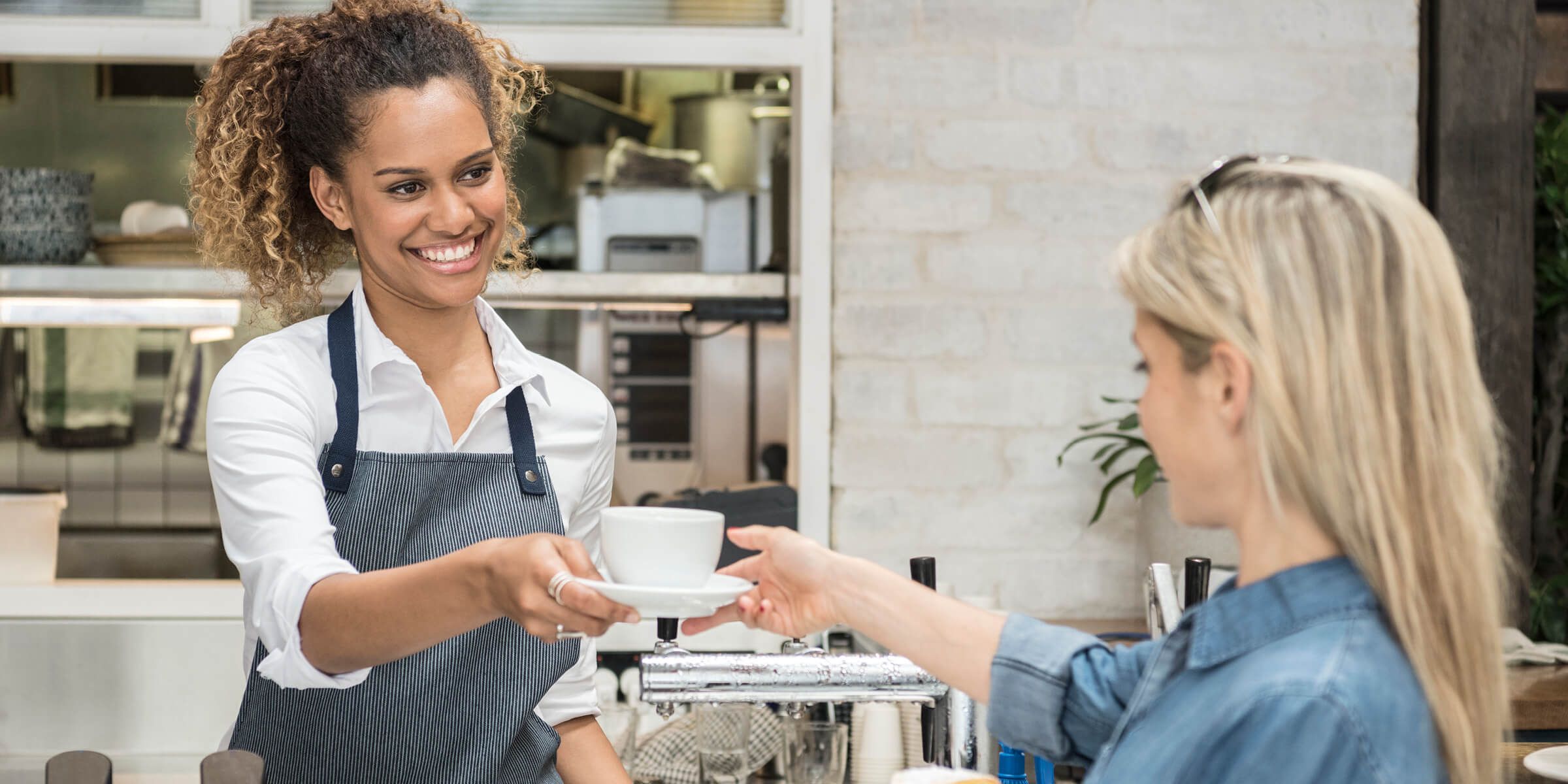 Woman serving another woman coffee