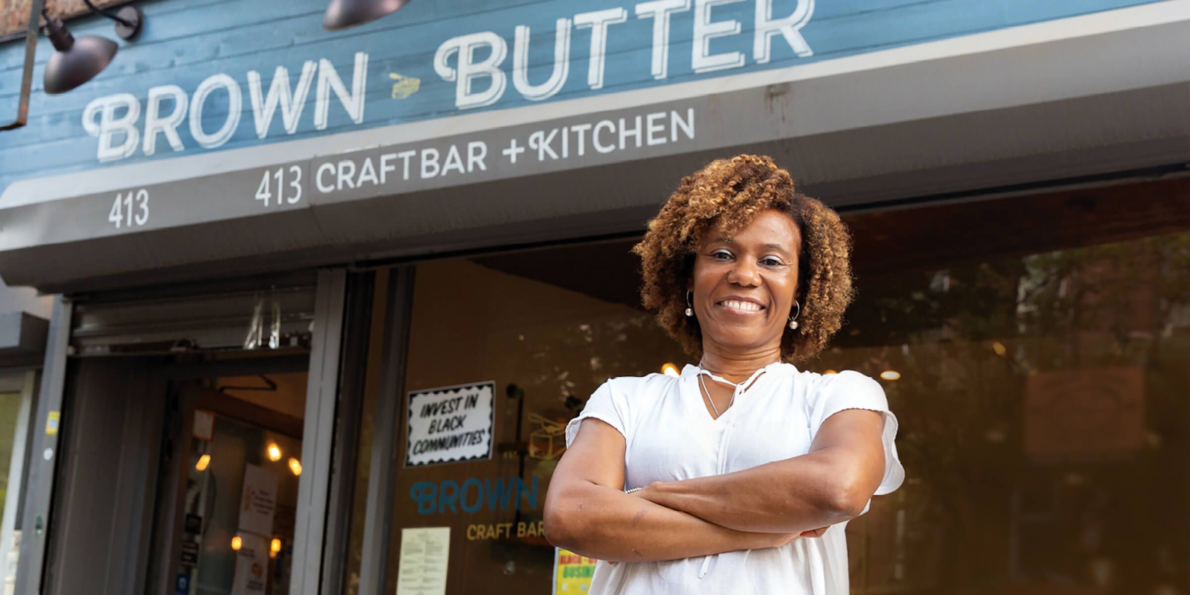 small business woman smiling outside of store