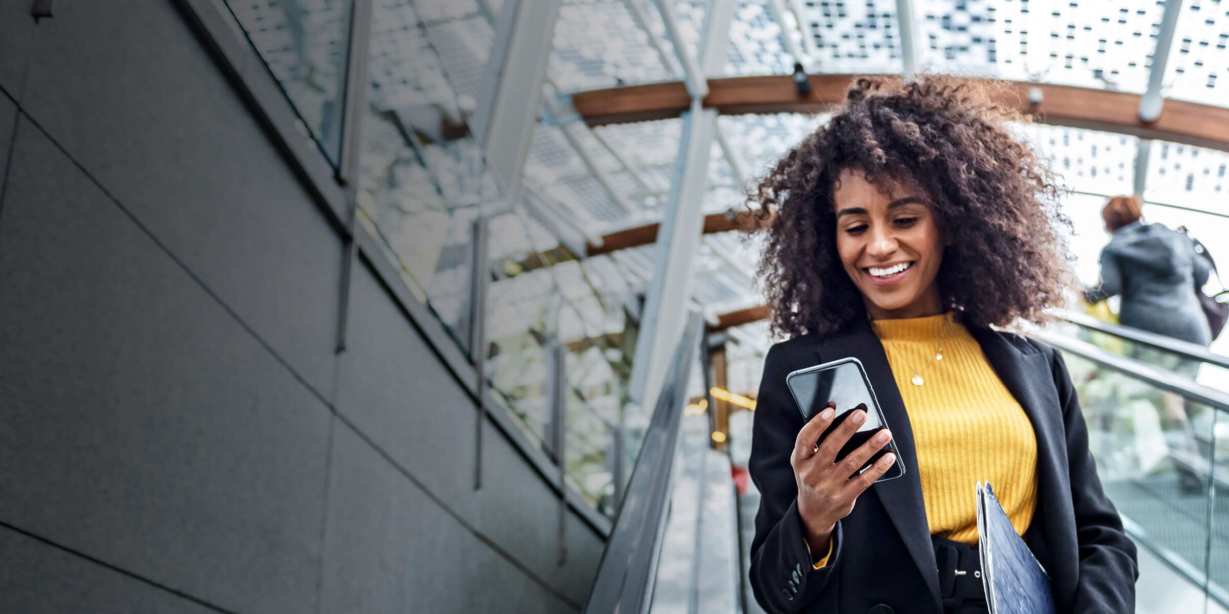 a woman smiling while holding a phone