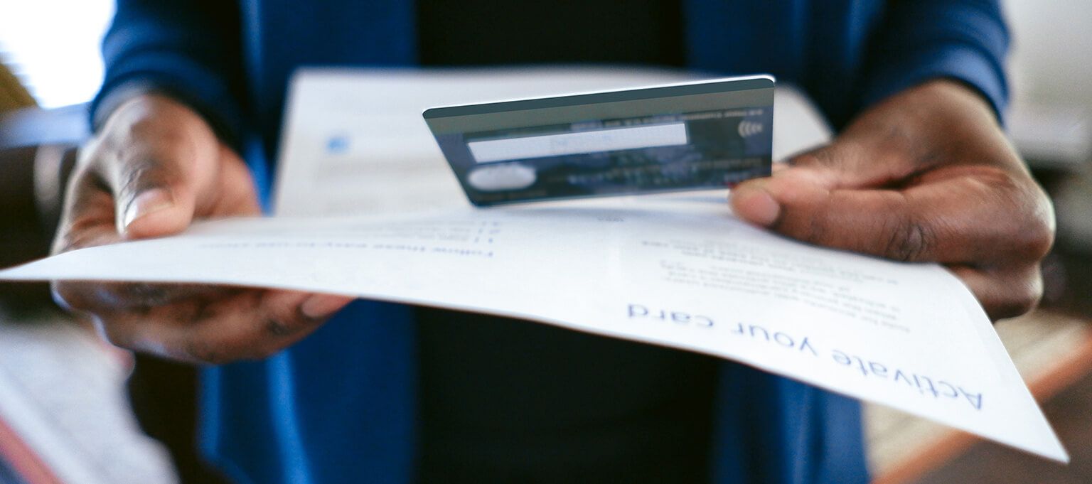 a person holding a paper and an electronic card