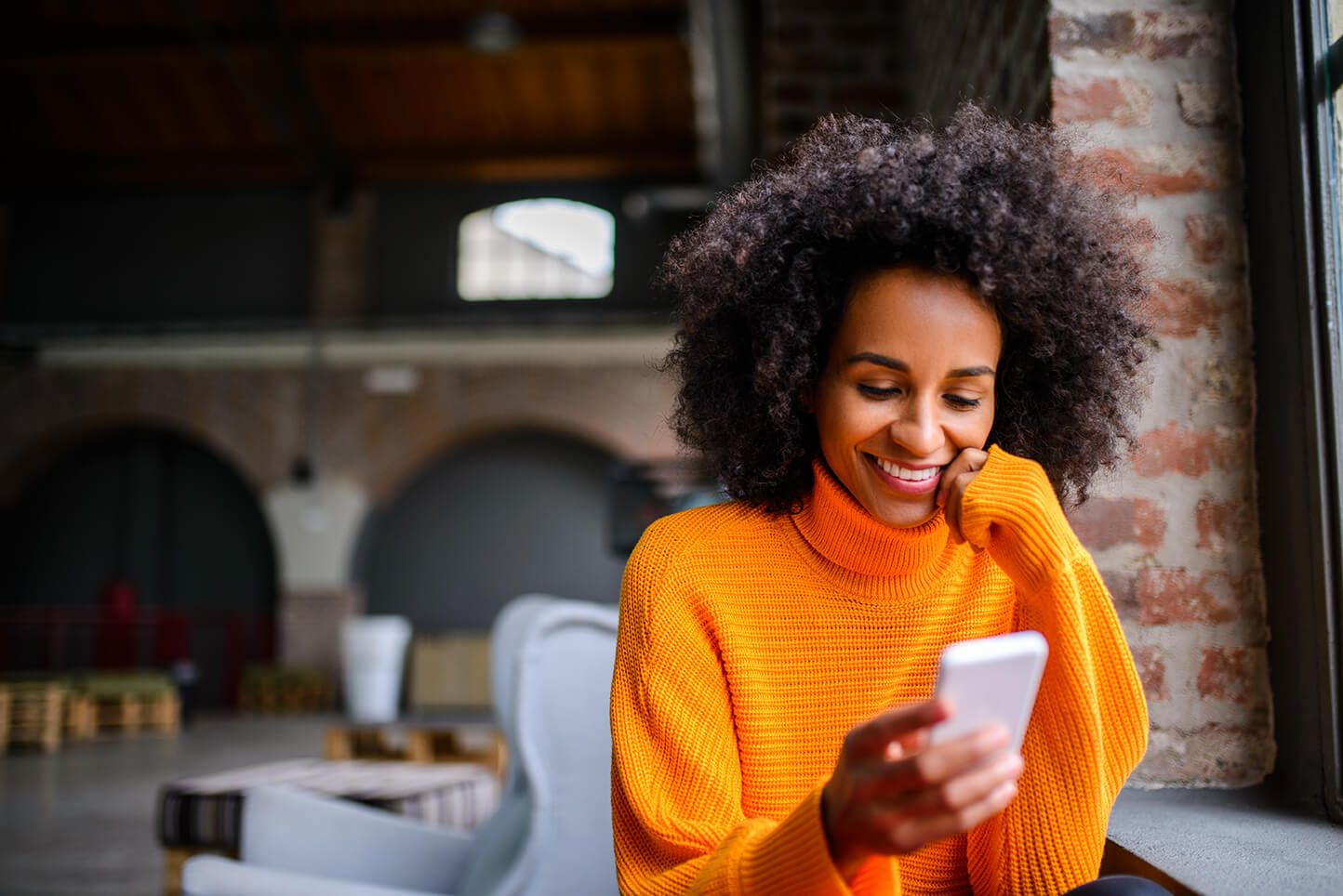 Woman sitting at table looking at phone