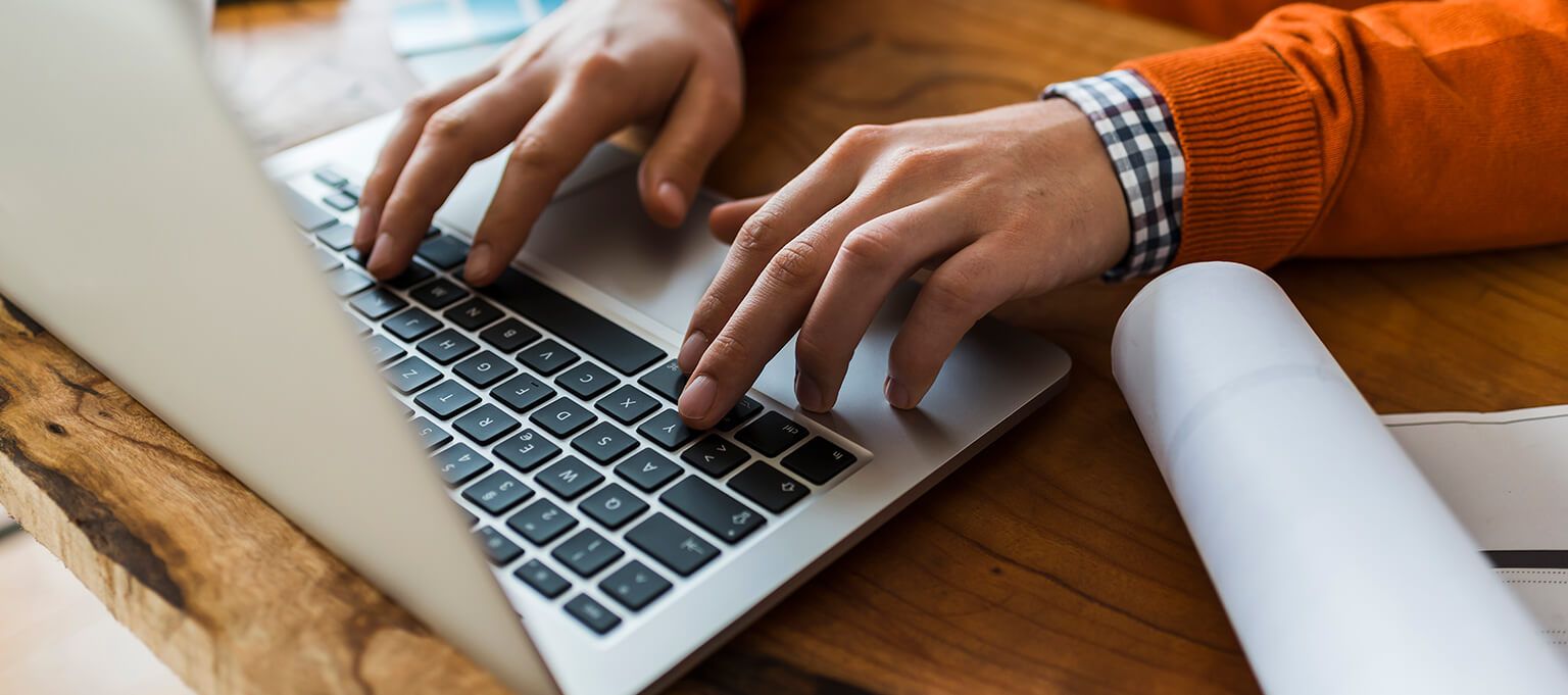 close up of person’s hand typing on a laptop