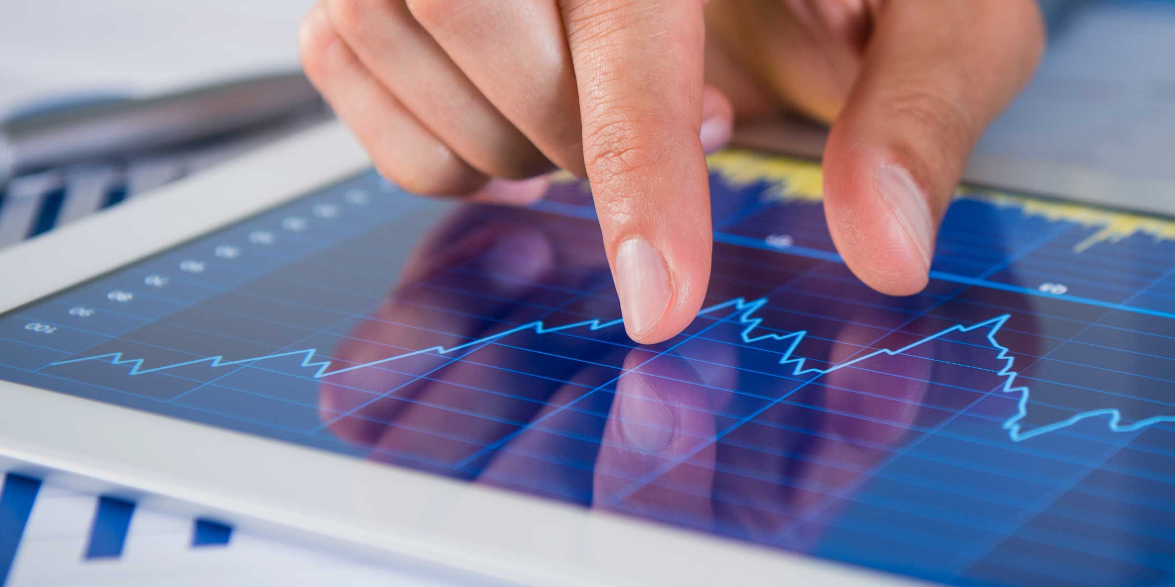 a finger touching a graph on a tablet