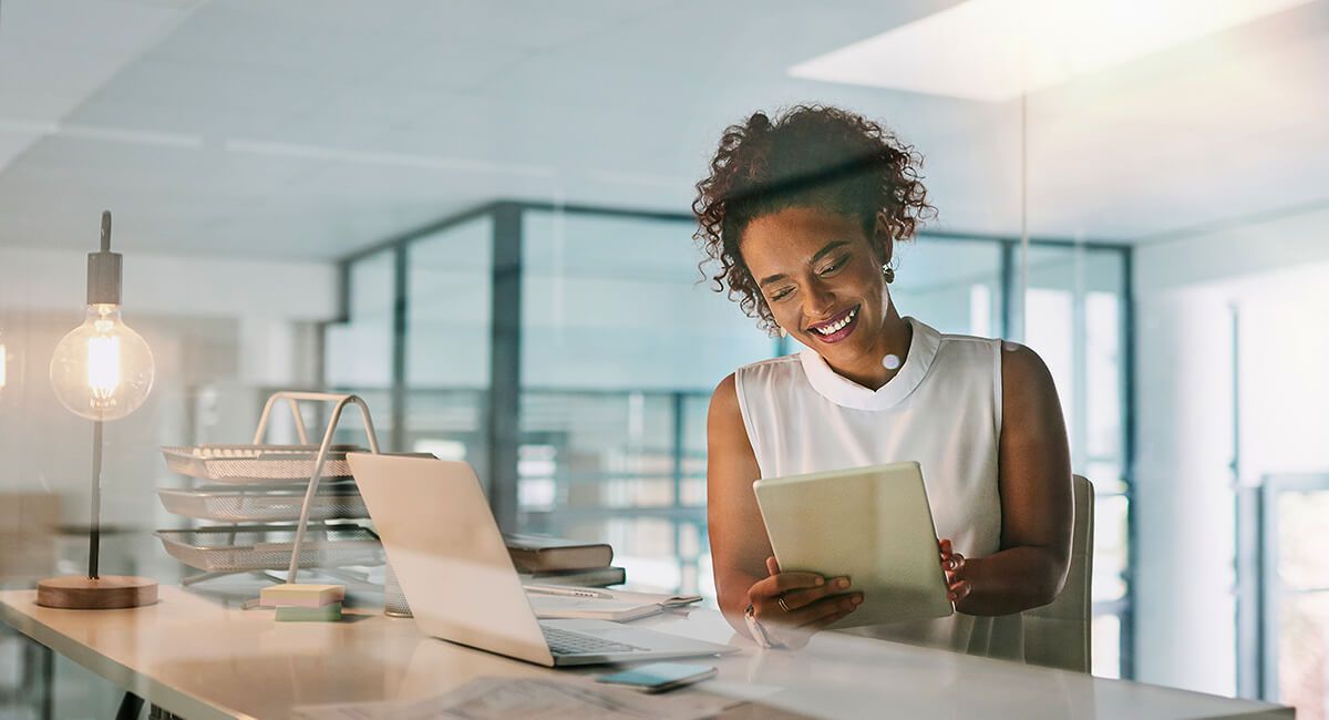 Women sitting at counter smiling looking at tablet