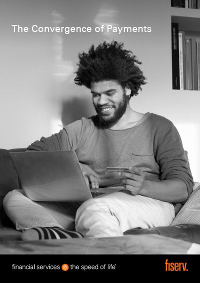 a man sitting on a couch and using a laptop and electronic card