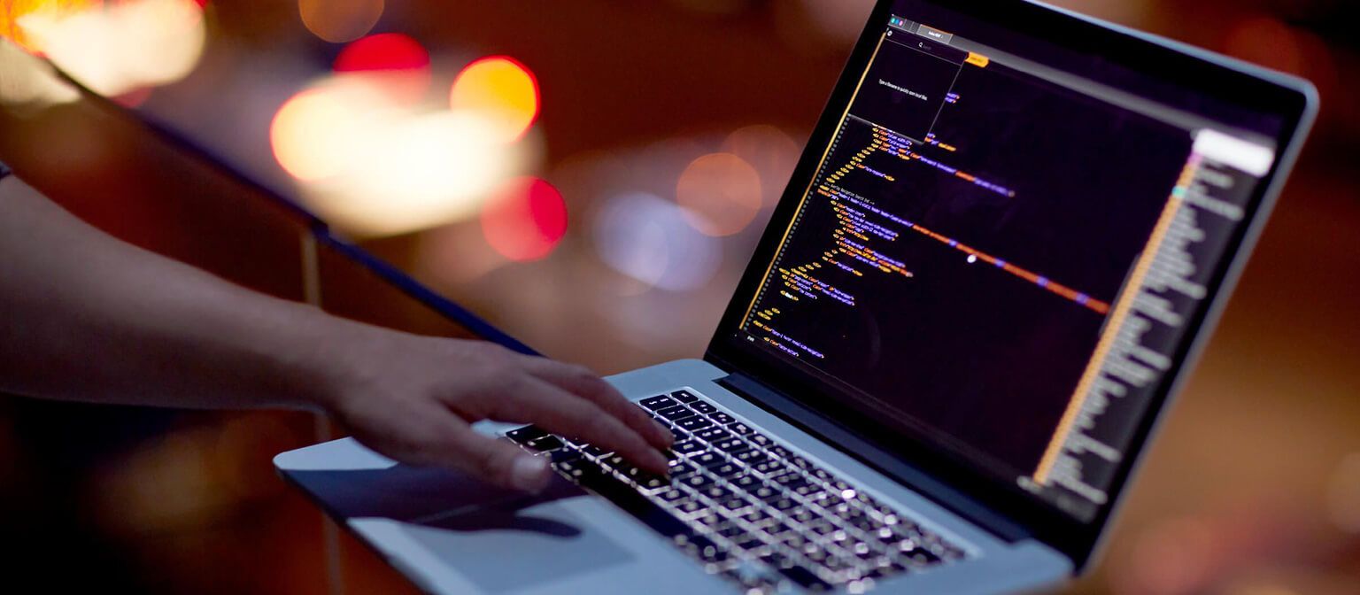 Man typing on a laptop keyboard