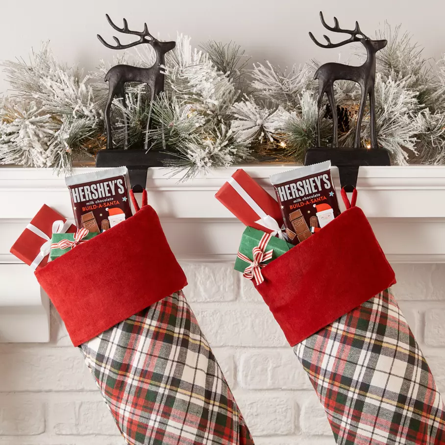 HERSHEY'S Build-A-Santa Candy Bars inside stockings along mantle