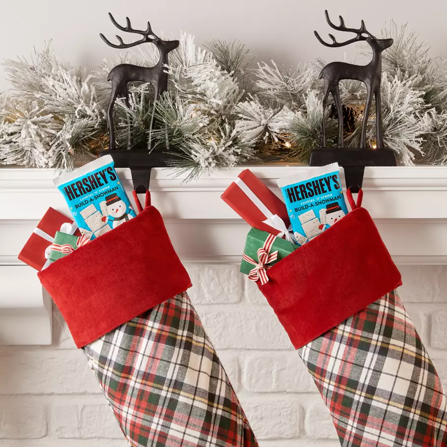 HERSHEY'S Build-A-Snowman Candy Bars inside stockings along mantle