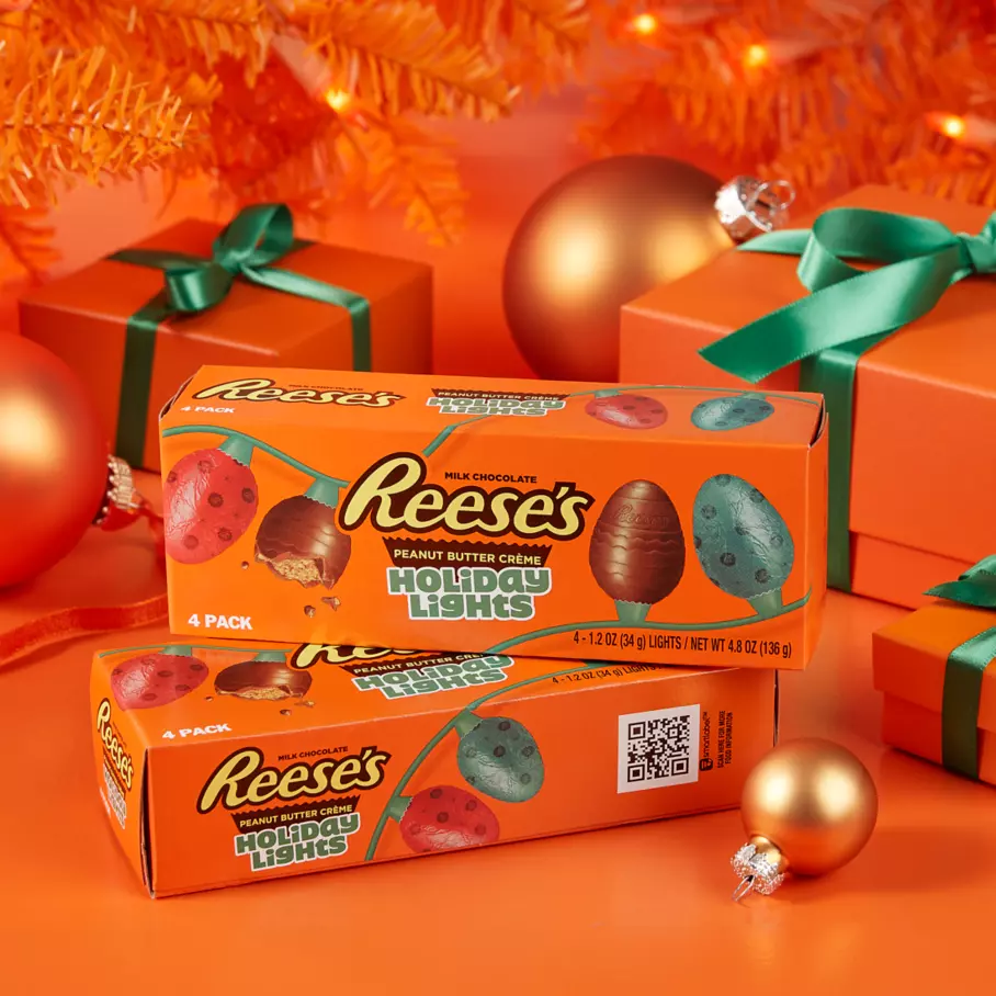 REESE'S Holiday Lights package underneath christmas tree surrounded by gifts