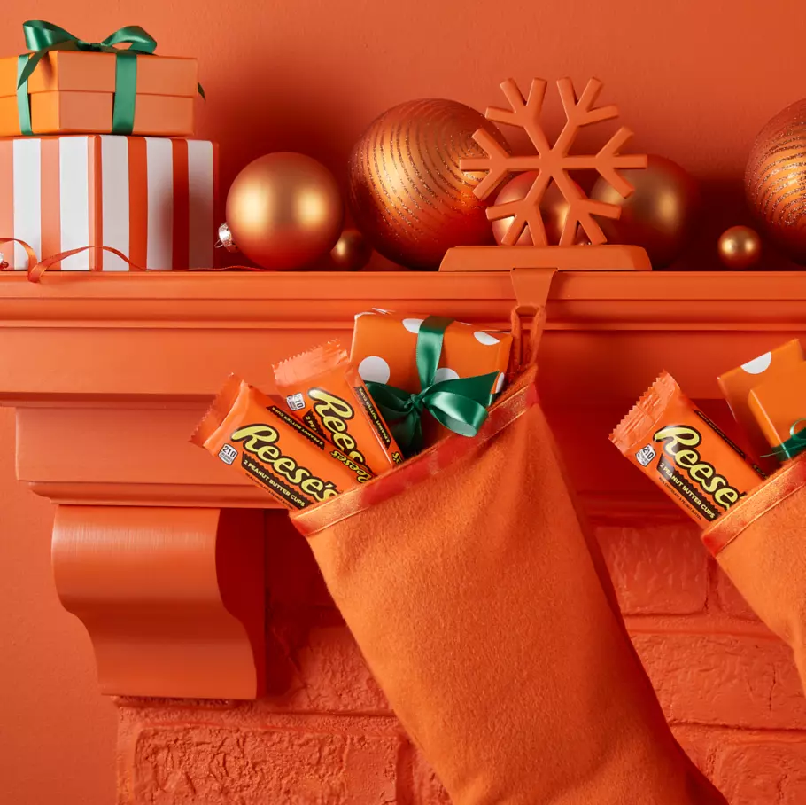 REESE'S Holiday Peanut Butter Cups inside stockings hanging from mantle