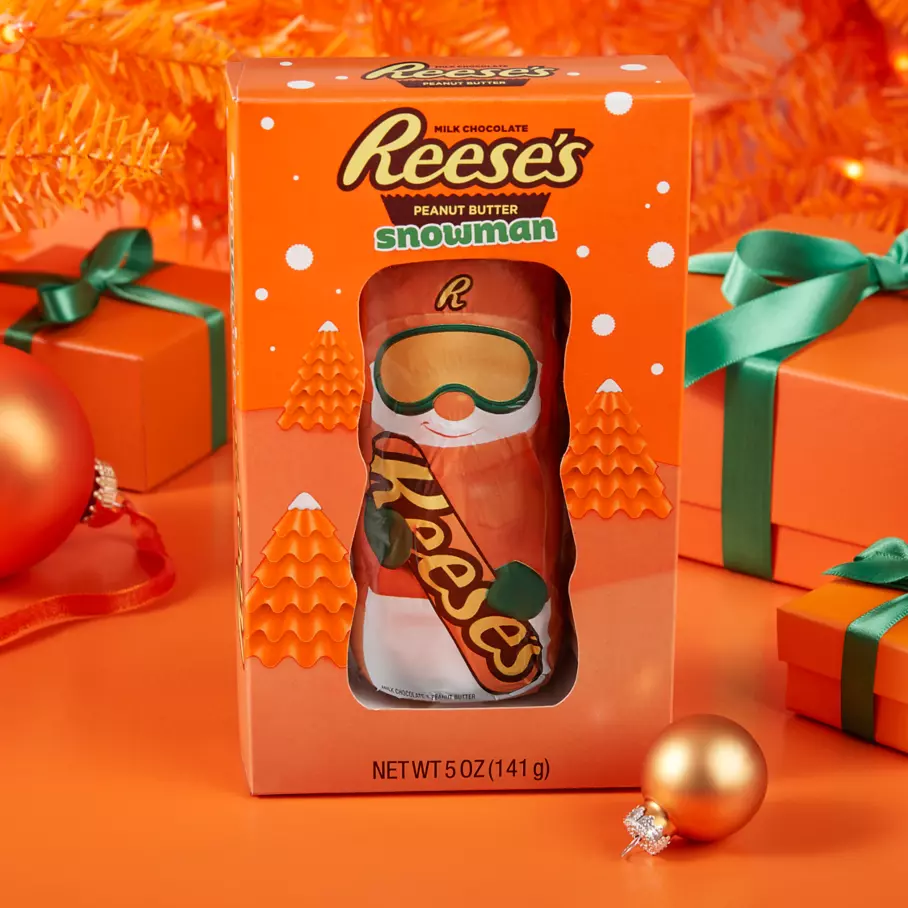 REESE'S Peanut Butter Snowman package under tree surrounded by gifts