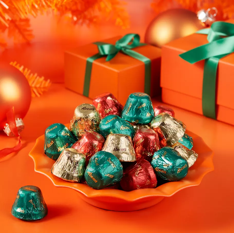 REESE'S Bells inside decorative bowl surrounded by gifts and ornaments