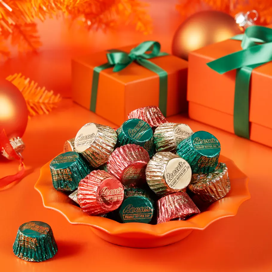 REESE'S Peanut Butter Cups inside decorative bowl surrounded by gifts and ornaments