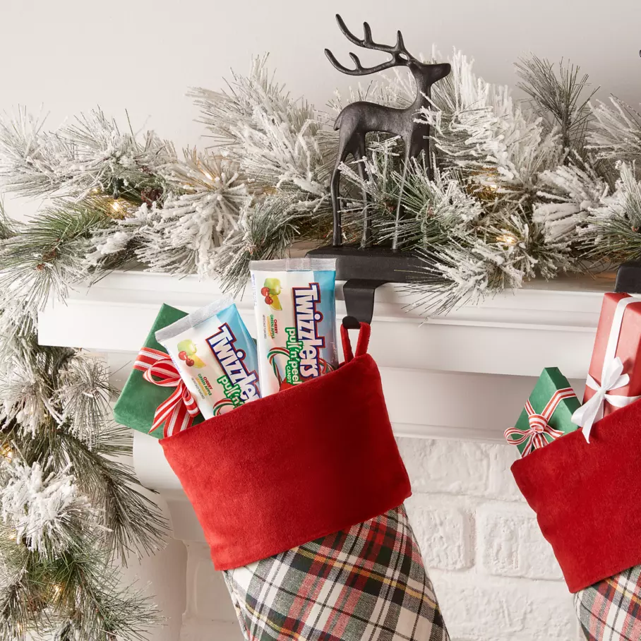 TWIZZLERS PULL ‘N’ PEEL Candy inside stockings hanging from mantle