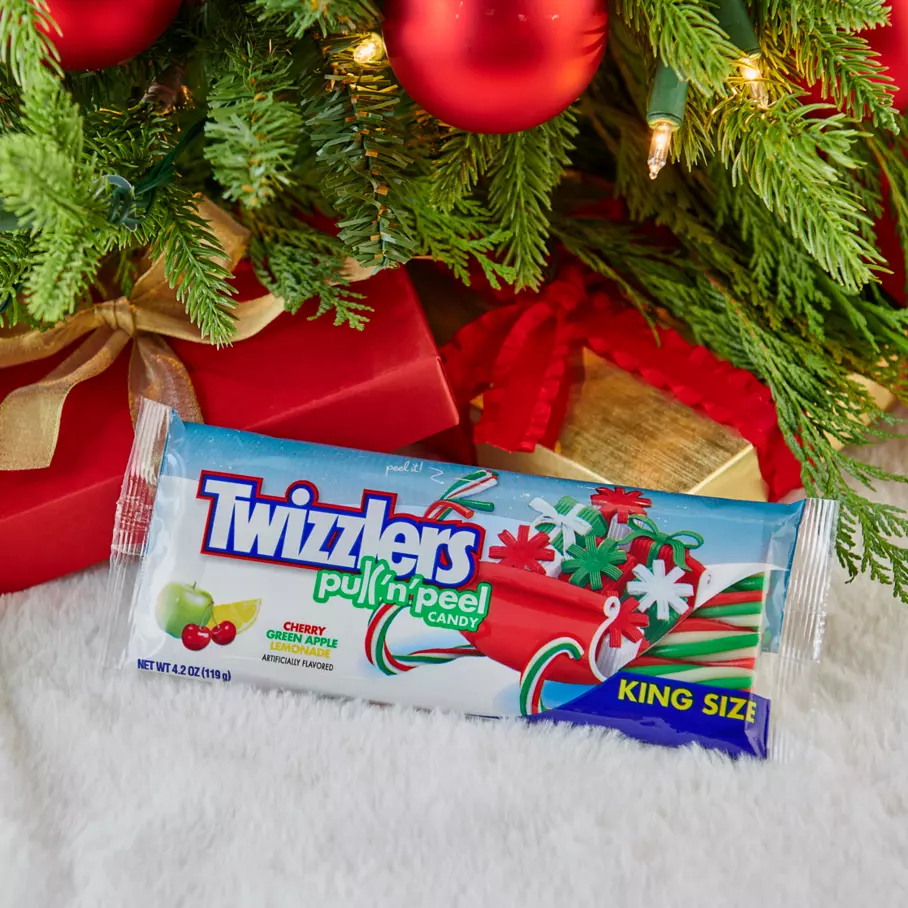 TWIZZLERS PULL ‘N’ PEEL Candy underneath christmas tree surrounded by gifts