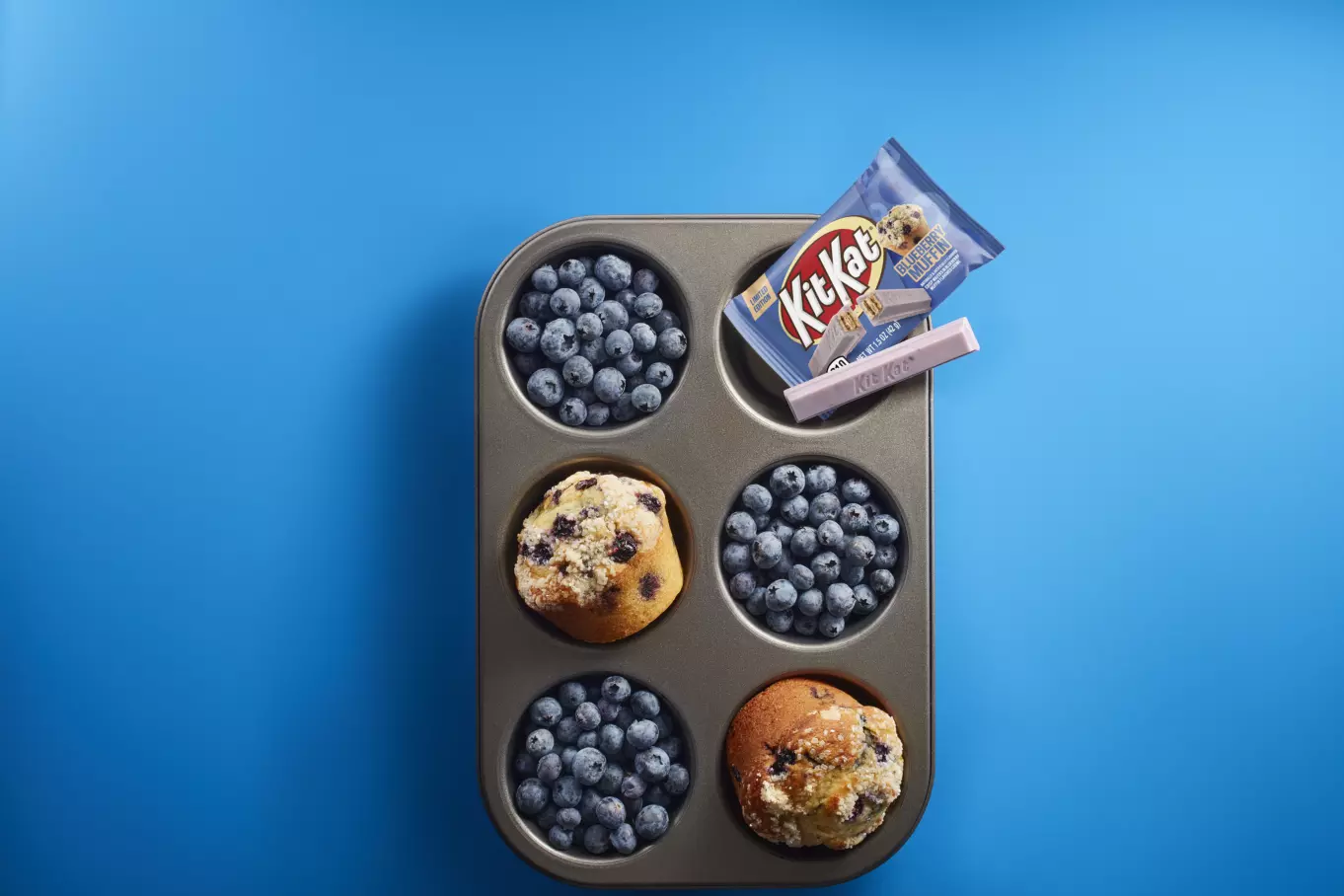 KIT KAT® Candy Bar inside muffin tin with blueberries and muffins