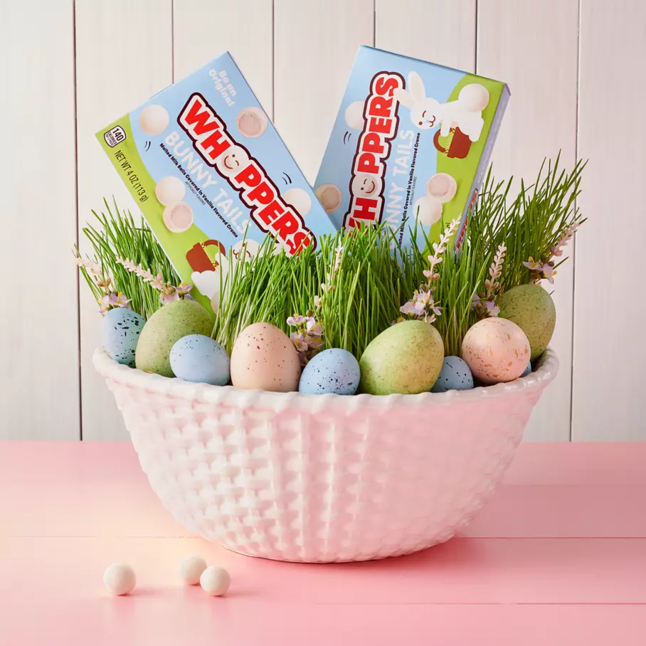Boxes of WHOPPERS Bunny Tails inside Easter basket surrounded by colored eggs