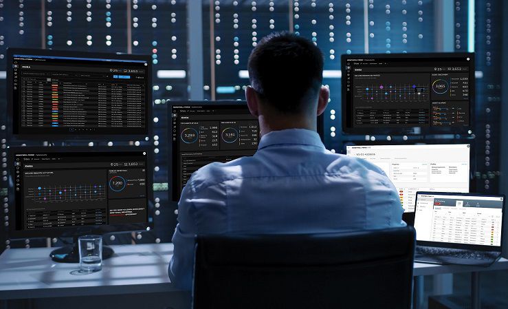 Man monitoring systems on multiple monitors