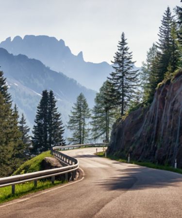 Empty, winding road alongside a mountain