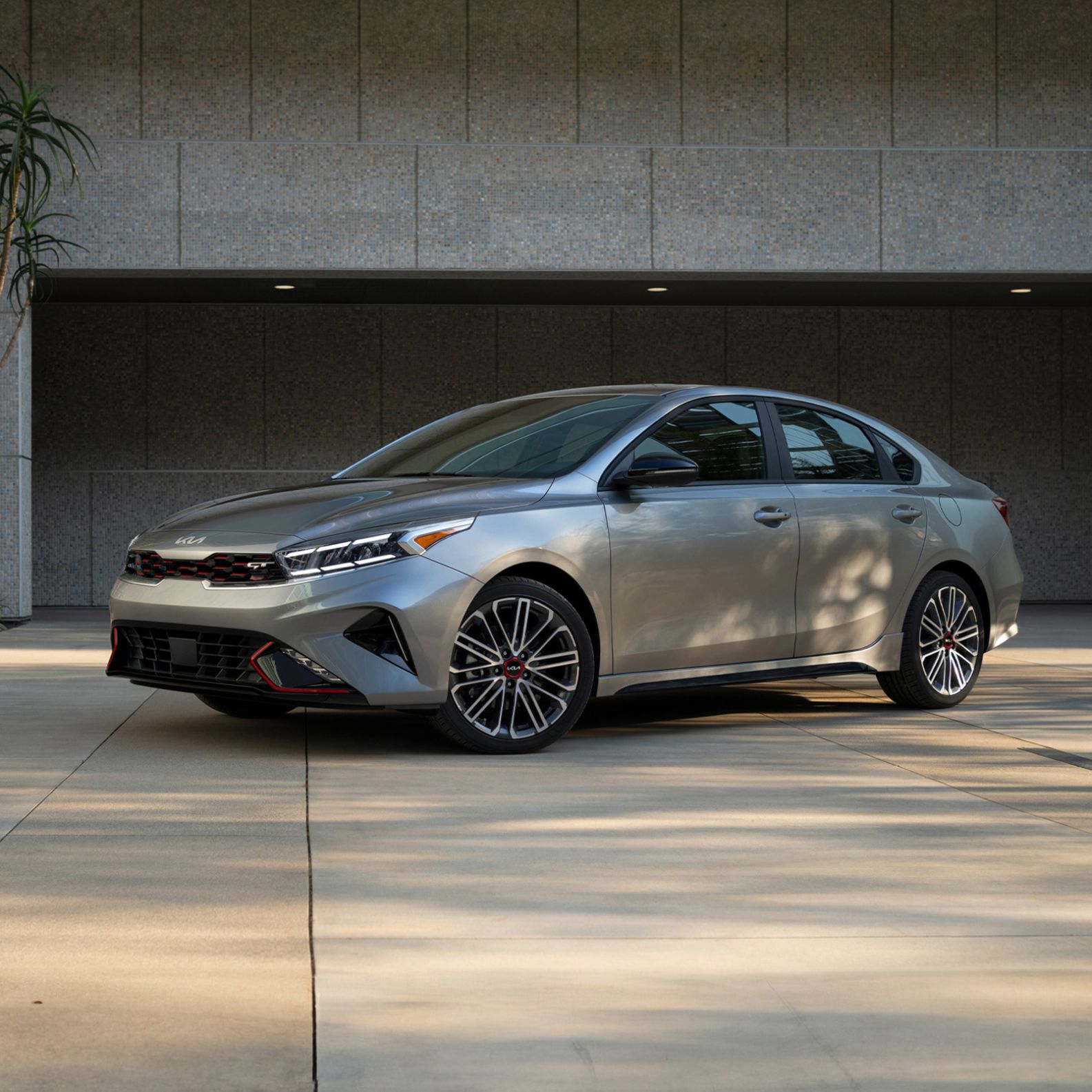 2024 Kia Forte in grey displaying alloy wheels and front LED lighting, three-quarters view