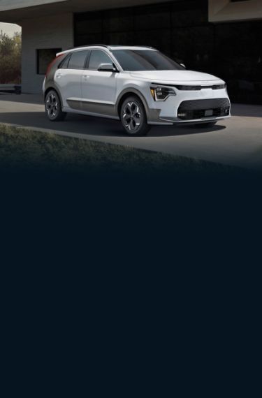 2023 Kia Niro EV Parked In Front Of A Large House Three-Quarter View