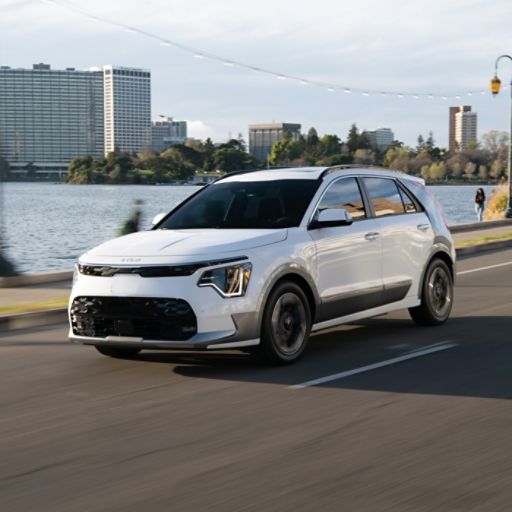 2024 Kia Niro EV Driving By A Lake Near The City Three-Quarter View