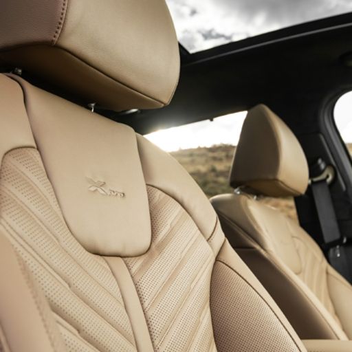 2024 Kia Sorento interior zoomed in view of the brown leather passenger seat featuring chevron detailing and the "X-Pro" emblem