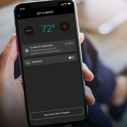 A hand holding a phone with a screen that displays the car temperature settings