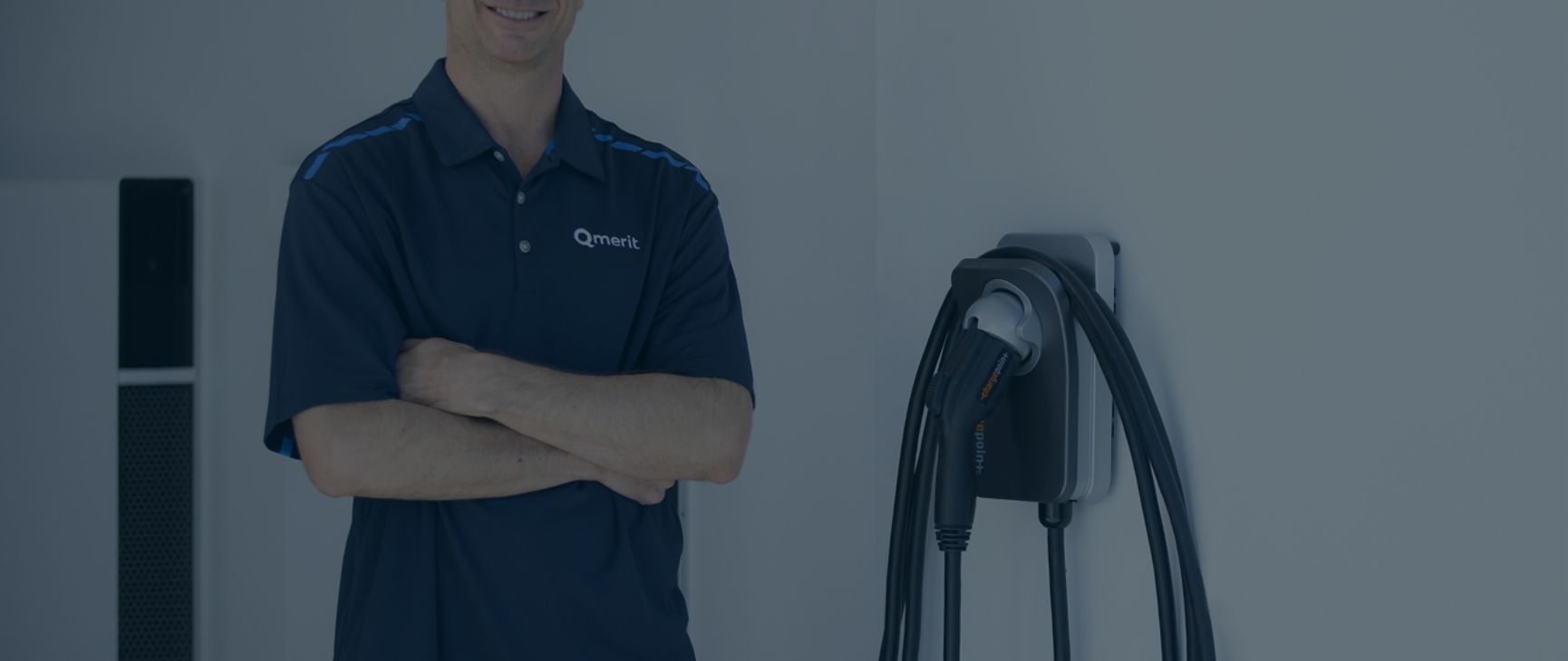 Qmerit worker standing by an installed wall charger