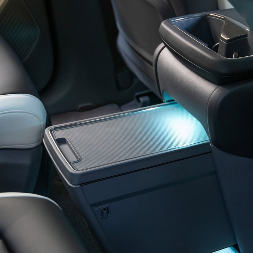 Extendable second row center console for concealable storage with charging ports
