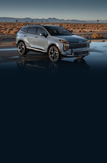 MY26 Kia Sportage Hybrid, three-quarter view, parked on a road in the desert