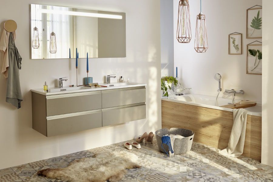 Une salle de bains avec un grand meuble vasque, une baignoire et un panier de rangement posé à terre