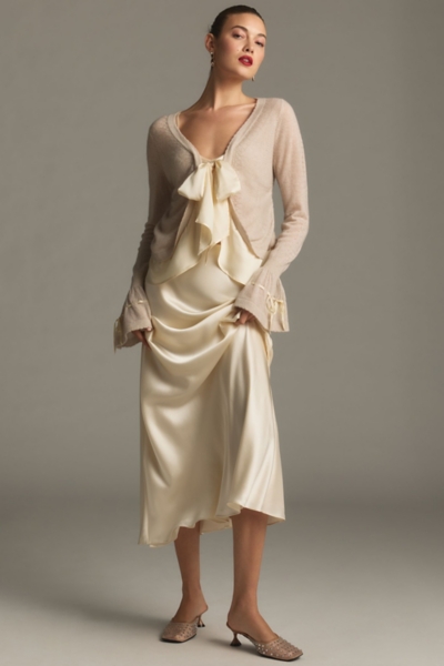 Woman in a beaded cardigan with a satin skirt