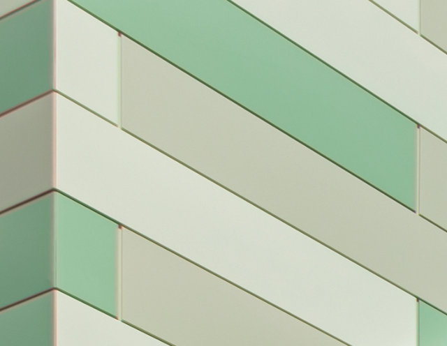 Close up of architectural building with green color-shifting geometric pattern.