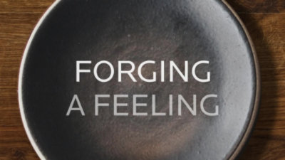 a black circular object with "Forging a feeling" overlayed
