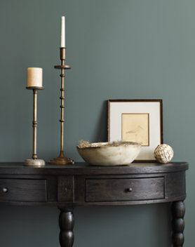 dark wood console table with candlesticks and a picture frame on top