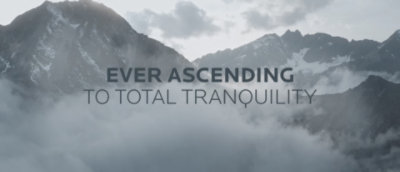 Misty mountains with "Ever Ascending to Total Tranquility" overlayed