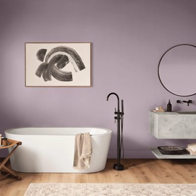 A bathroom painted Mauve Finery SW 9282 with a large soaking tub and floating stone sink.