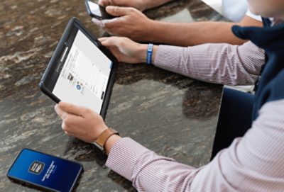 A person holding a tablet with the contact a rep form on the screen and their smart phone on the table with the Pro App open.