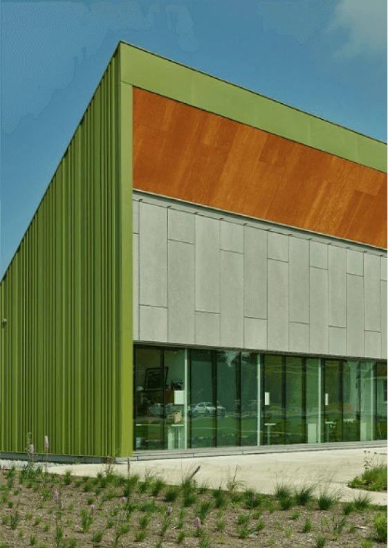 A modern style commercial building painted green with wood and concrete accents.