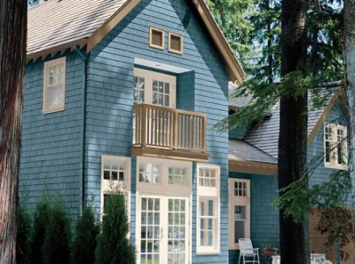 A light blue painted house with a balcony.