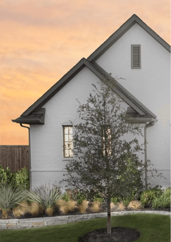 The exterior of a brick home painted white with dark gray and black accents and roof.
