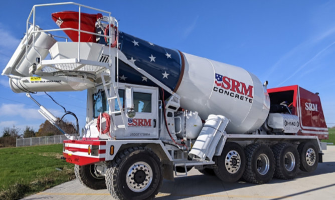 Full side view of a completed SRM Concrete front-discharge mixer truck with a glossy red, white and blue finish.