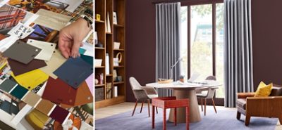 A person sorting through various color chips. A room with a round table, chairs, and floor to ceiling window and shelves.