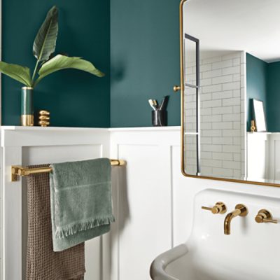 A bathroom with a mirror, white sink, towel rack and walls painted in SW 7623 Cascades.