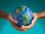 Two hands holding a small globe