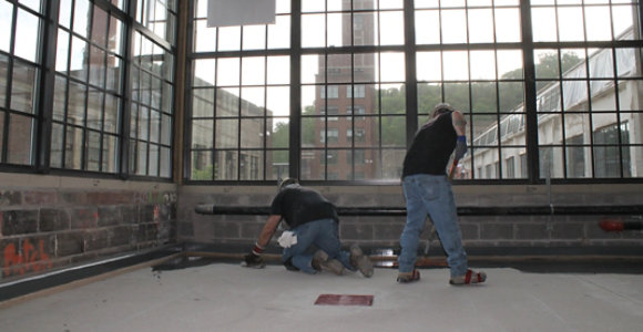 Workers installing a floor in a brewery